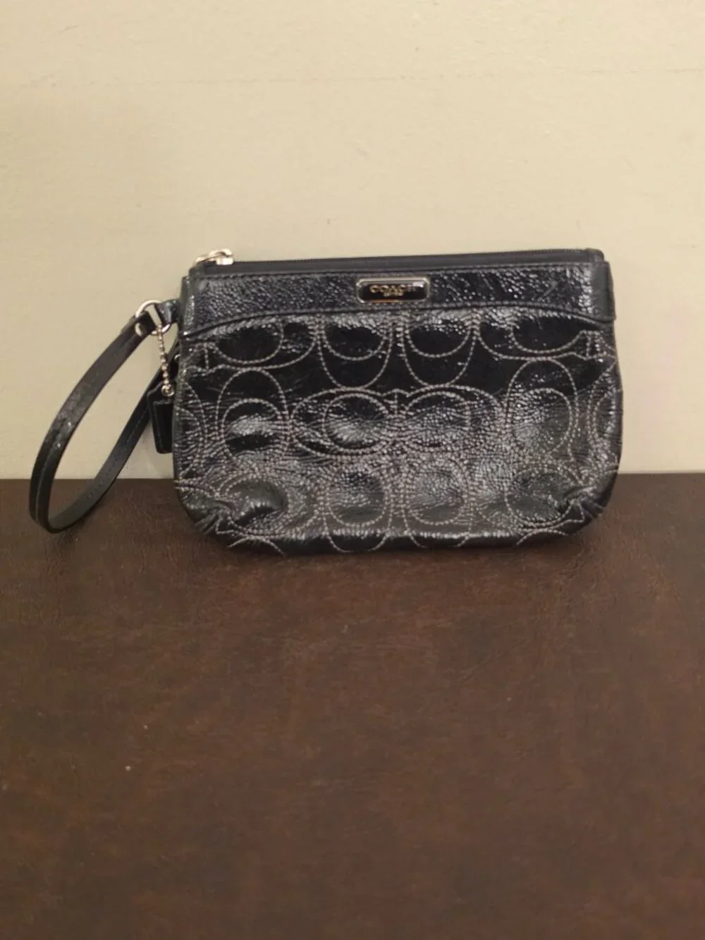 The Coach Signature Stitched Patent Leather Wristlet in black silver
